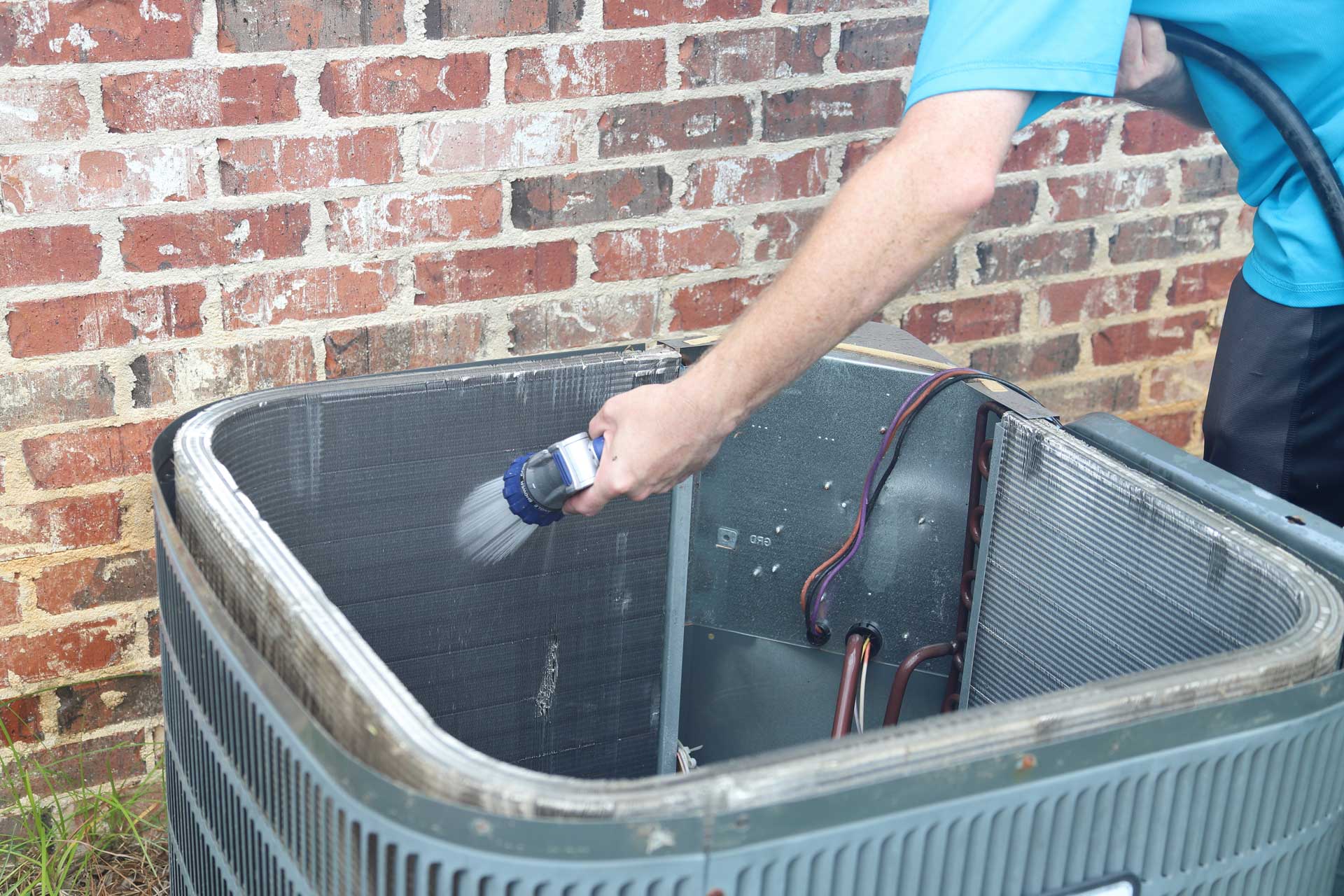 HVAC technician cleaning a unit