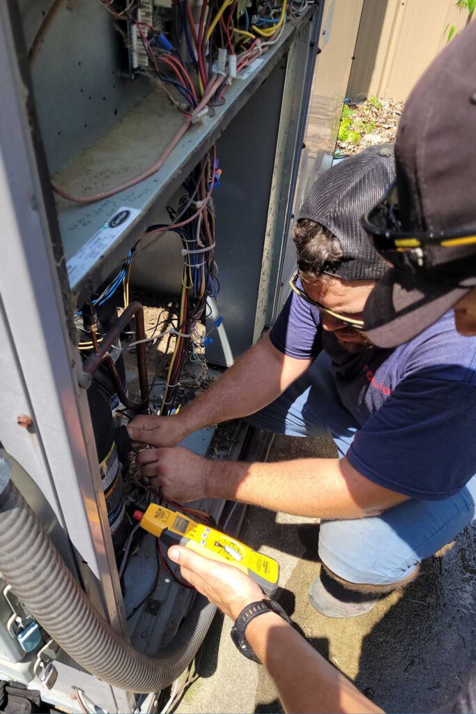 Two Cool-Serv HVAC technicians working